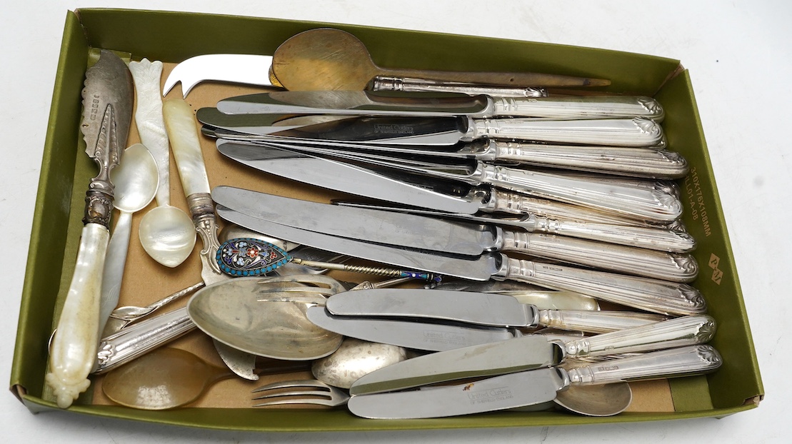 A small group of assorted silver and white metal cutlery including teaspoons, mother of pearl handled butter knives, a set of eight modern silver fiddle and shell pattern handled table knives and a matching set of eight